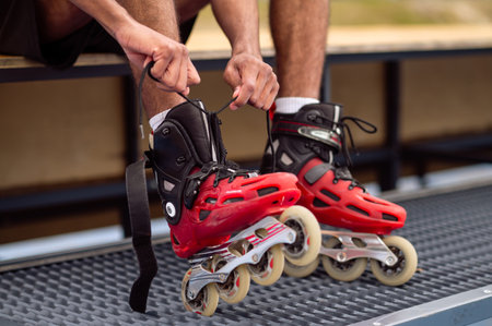 Young man putting on red rollers before the ride