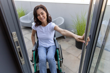 Dark-haired woman on a wheelchair at the office entrance
