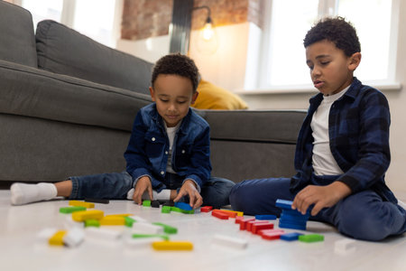 Cute boys friends playing with colorful constructorの写真素材