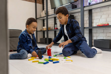 Cute boys friends playing with colorful constructorの写真素材