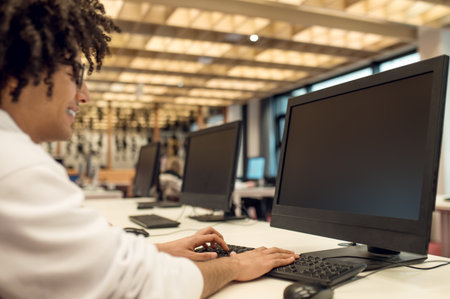 Man researching for college project via computer while sitting in library