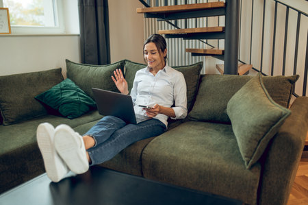Dark-haired woman working from home and looking involvedの写真素材