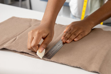 Woman tailor working with fabric marked out pattern of the garment making with tailors chalkの写真素材
