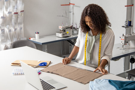 Hard working woman working on fashionable couture handling beautiful fabricsの写真素材