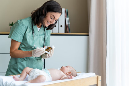 Doctor giving dose of syrup to sick baby in the clinicの写真素材
