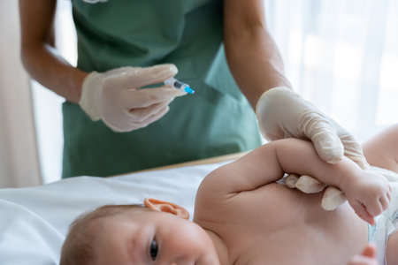 Pediatrician administers an injection to baby during routine checkup at hospitalの写真素材