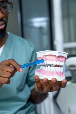 Male doctor providing dental care on model in the clinic, treating caries