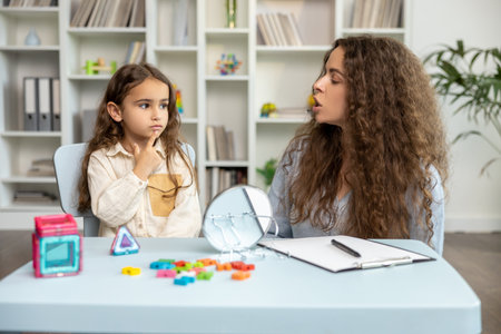 Female speech therapist working with a girl on her articulationの写真素材