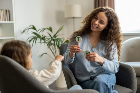 Smiling speech therapist working with a child and looking involved