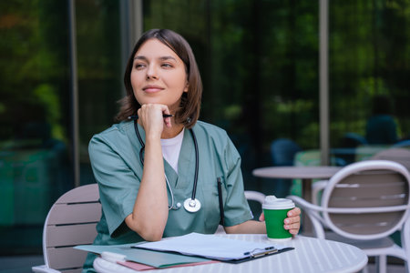 Young female doctor having a coffee break and looking relaxedの写真素材