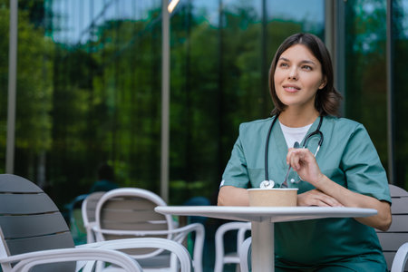 Young female doctor having lunch and looking enjoyedの写真素材