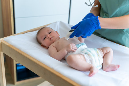 Unrecognizable doctor or nurse monitoring babys temperature with digital thermometerの写真素材