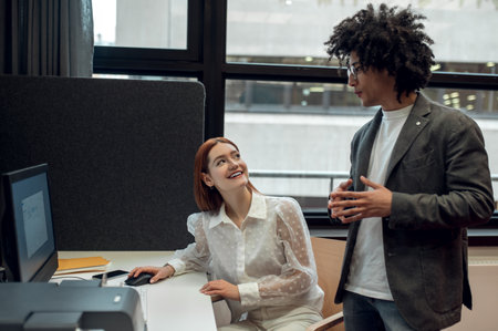 Young man and young woman working together on the project in the officeの写真素材