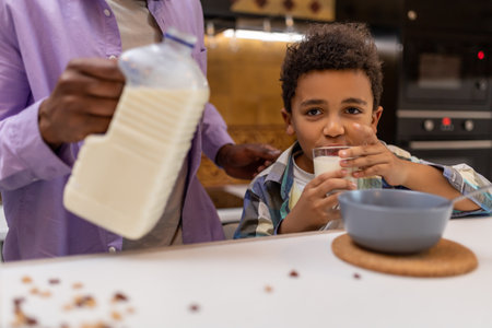 Father and kids having breakfast together in the kitchenの写真素材