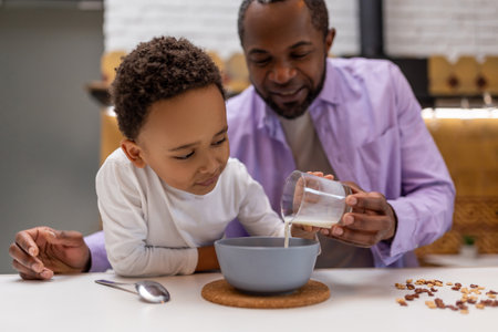 Father and kids having breakfast together in the kitchenの写真素材