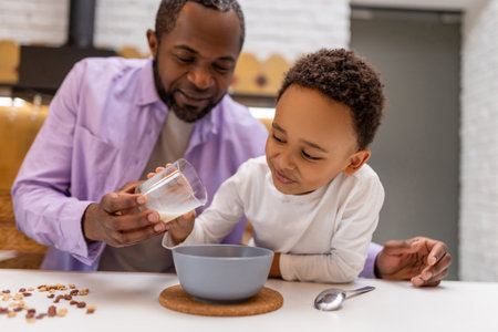 Father and kids having breakfast together in the kitchenの写真素材