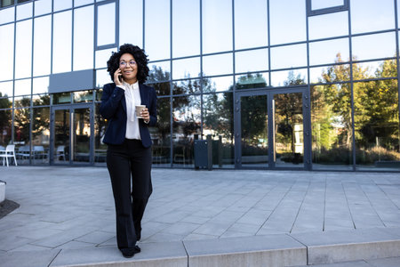 Business woman having coffee and talking on the phoneの写真素材