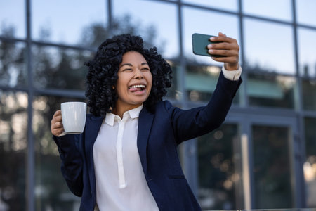 Elegant business woman having coffee and making funny selfie
