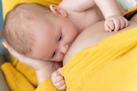Anonymous woman breastfeeding newborn kid in the nurseryの写真素材