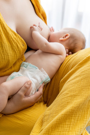 Anonymous woman breastfeeding newborn kid in the nurseryの写真素材