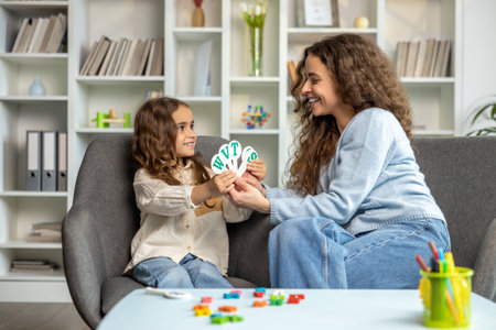 Speech therapist working with a girl and both looking involvedの写真素材