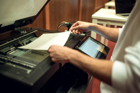 Young man making copies on xerox in the library