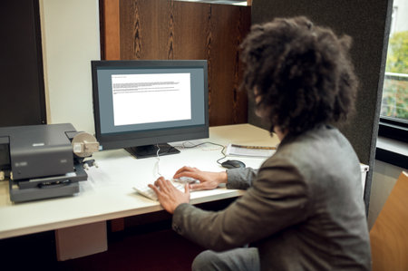 Young curly-haired businessman in the office looking confident