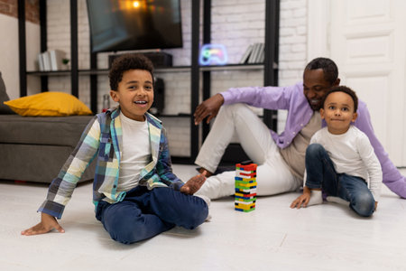 African american family sitting on the floor and playing jengaの写真素材