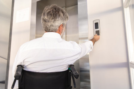 Businessman in wheelchair in corporate office using digital key to operate the lift