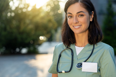 Pretty young female doctor looking thoughtful in the light of morning sunの写真素材