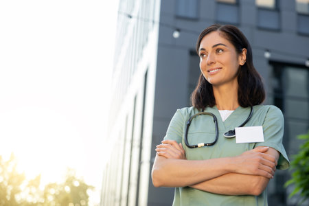 Pretty young female doctor looking thoughtful in the light of morning sunの写真素材