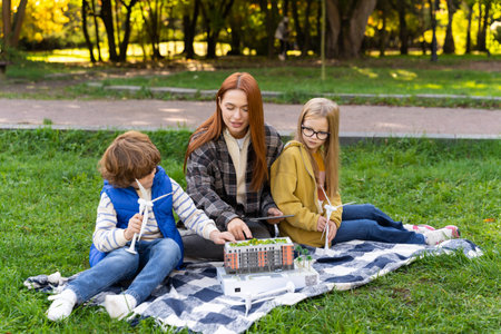 Woman volunteering at camp with children using models of wind turbines and digital tabletの写真素材