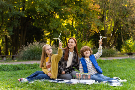 Teacher guiding children on tablet while discussing wind energy and environmentの写真素材