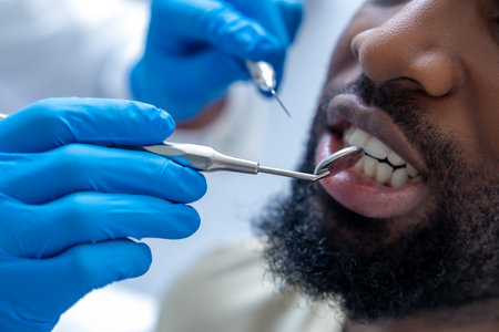 Professional dentist in modern office checking patients gums with dental toolの写真素材