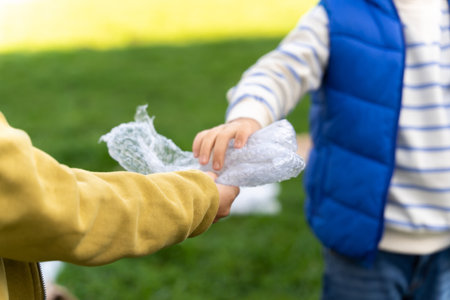 Children working together in park to protect environment collecting trashの写真素材