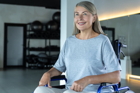 Blonde mature woman sitting in a wheel-chair and looking positiveの写真素材