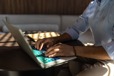 Unrecognizable man using laptop while working in officeの写真素材