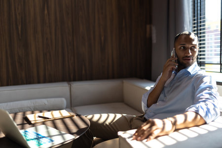 Dark skinned businessman talking on mobile phoneの写真素材