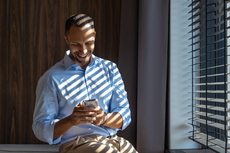 Businessman holding smartphone in office using digital technology applicationの写真素材
