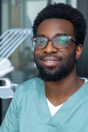 Man dentist in glasses in medical office during dental examinationの写真素材