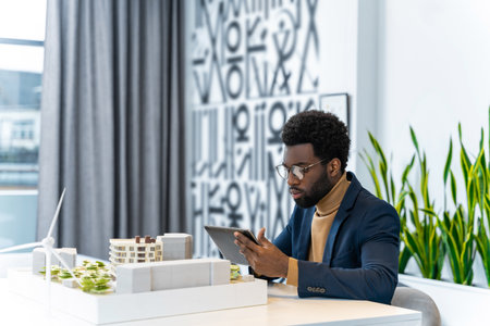 African american architect looking focused while scrutinizing the new mock up of a living building