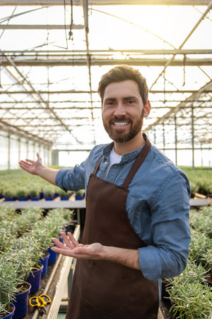 Positive bearded young man in a greenhouse looking determinedの写真素材