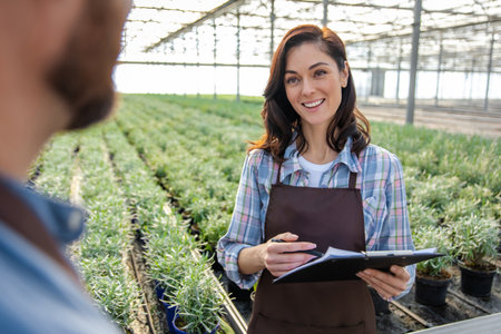 Glasshouse workers talking after quality control check and looking contentedの写真素材