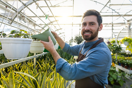 Greenhouse workers watering flowers in a glasshouseの写真素材