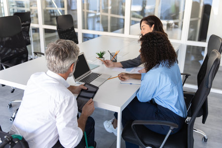 Determined businesswoman with coworkers using technologyの写真素材