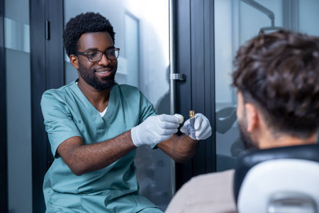 Male stomatologist with patient during dental visit before implanting teethの写真素材