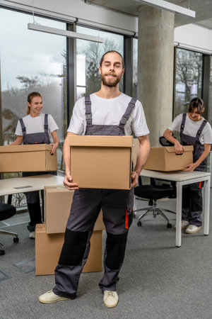 Bearded caucasain packaging center worker with a cardboard box in hands