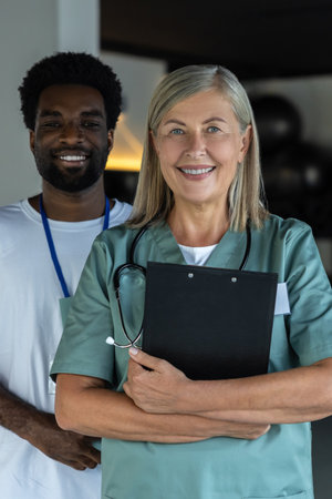 Female doctor in medical scrubs with an african american intern in the clinicの写真素材