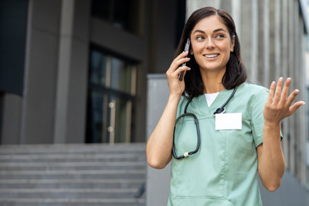 Young female doctor talking on the phone with a patient and looking involved and friendlyの写真素材