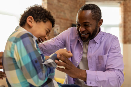 Father and son at home getting dressed in the kitchen and looking enjoyedの写真素材